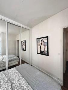 a white bedroom with a bed and a mirror at Cozy 1BR in the Heart Of Paris in Paris