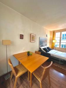 a living room with a table and chairs and a bed at Cozy 1BR in the Heart Of Paris in Paris