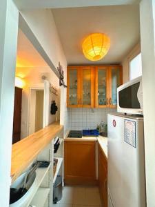 a kitchen with a white refrigerator and a microwave at Cozy 1BR in the Heart Of Paris in Paris