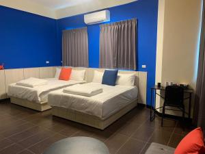 金城鎮的住宿－玩轉金門 ，一间卧室设有两张带蓝色墙壁的床