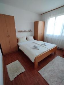 a bedroom with a large bed with white sheets at Apartman Unac in Drvar