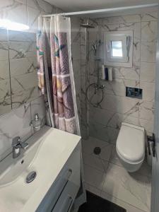 a bathroom with a sink and a toilet and a shower at Aegean Pearl Studio in Tinos Town