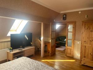 um quarto com uma cama e uma televisão de ecrã grande em Family House Apartments em Salacgrīva