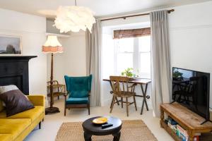 a living room with a yellow couch and a table at Seaside Hideout - close to beach in Eastbourne