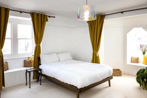 a bedroom with a bed with yellow curtains at Seaside Hideout - close to beach in Eastbourne