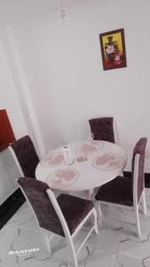 einen weißen Esstisch mit Stühlen und einem weißen Tisch in der Unterkunft Peaceful Palace in Kisumu