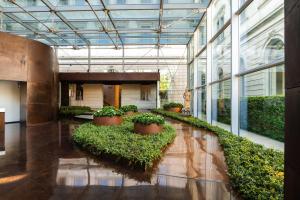a lobby with plants in pots in a building at Lido Palace - The Leading Hotels of the World in Riva del Garda