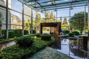 a lobby with plants and a large glass building at Lido Palace - The Leading Hotels of the World in Riva del Garda