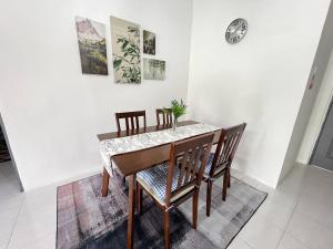 comedor con mesa y sillas en Aufa Homestaymuslim's 2 at Emerald Avenue, en Brinchang