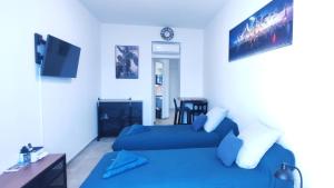 - une chambre avec 2 lits bleus et une télévision dans l'établissement Le QG, à Cannes