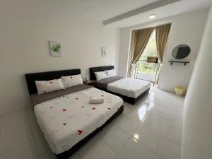 1 dormitorio con 2 camas y ventana en Aufa Homestaymuslim's 2 at Emerald Avenue, en Brinchang