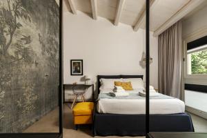a bedroom with a bed and a table and a mirror at Embrace Sicily Guest House in Noto