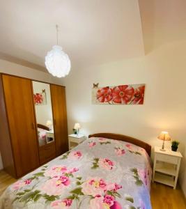 um quarto com uma cama com flores cor-de-rosa em Gîte Les Roses - Plain-pied - Calme - WIFI Gratuit em Noyelles-sur-Mer