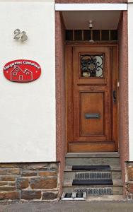 une maison avec une porte en bois et un panneau sur celle-ci dans l'établissement Margaretes Gästehaus am Rheinsteig Wanderer Radfahrer Familien Business-Reisende WLAN gratis, à Rheinbrohl