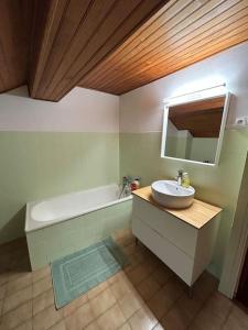 bagno con lavandino e vasca di Maison de village a Ussat