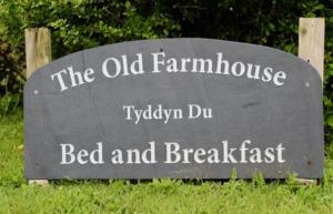 a sign for the old farmhouse bed and breakfast at The Old Farmhouse B&B in Dyffryn