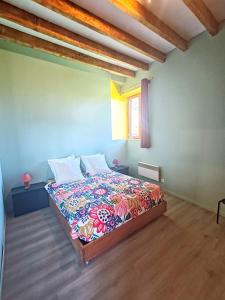 a bedroom with a bed with a colorful bedspread at Auberge du Précontent in Arfeuilles