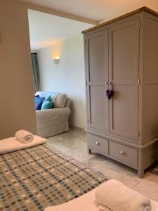 a bedroom with a large cabinet and a couch at Craig-Y-Mor Bed & Breakfast with sea views Whitesands St Davids in St. Davids