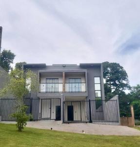 a house with a black fence and a yard at Sobrado da Renata no Centro de Foz in Foz do Iguaçu