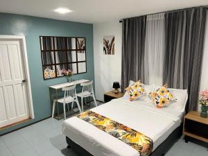 罗哈斯城B & B Suite Room的一间卧室，配有一张床和一张桌子和椅子