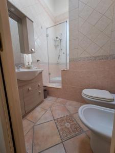 a bathroom with a shower and a toilet and a sink at ALICE B&B in Villasimius