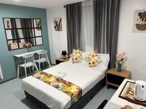 罗哈斯城B & B Suite Room的酒店客房设有一张床铺、一张桌子和一张桌子。