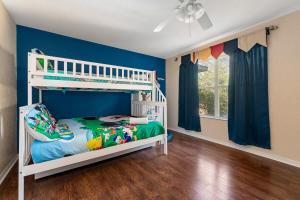 a bedroom with blue walls and a bunk bed at Resort w Lazy River and Arcade 30mis to Disney in Davenport