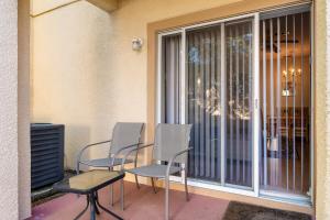two chairs and a table on a patio next to a window at Resort w Lazy River and Arcade 30mis to Disney in Davenport
