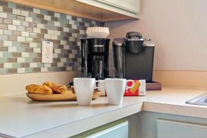 a kitchen counter with coffee cups and croissants on a table at Resort w Lazy River and Arcade 30mis to Disney in Davenport