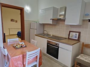 kuchnia ze stołem, zlewem i blatem w obiekcie Appartamento Mary w mieście Porto Cesareo