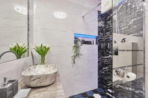 a bathroom with a shower with a large marble tub at Golden Hour Apartments- Plac Słowiański 36 in Świnoujście