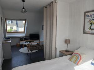 Schlafzimmer mit einem Bett, einem Schreibtisch und einem Fenster in der Unterkunft Plan B in Quimper