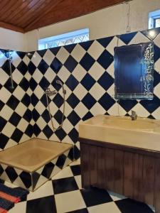 a bathroom with a black and white checkered wall at Bungalow Chez Mouch Nosy Be 7 in Nosy Be
