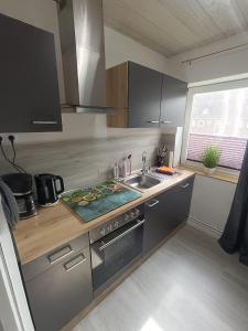 een keuken met een spoelbak en een fornuis bovenste oven bij Küstenliebe in Wilhelmshaven