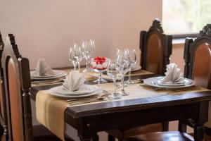 une table en bois avec des verres, des assiettes et des serviettes dans l'établissement Hotel Mira Serra, à Celorico da Beira