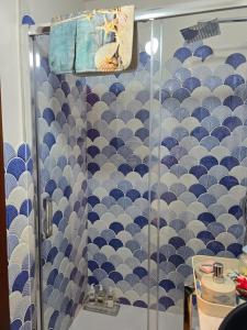 ducha con pared de azulejos azules y blancos en Muxía Apartamento Malecón enfrente al puerto 4 personas, en Muxía