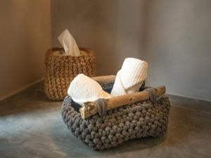 a basket with a wooden stick and two baskets with towels at Hostal Aljibe in Archidona