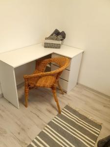 a desk with a wicker chair next to a desk at Apartamenty z widokiem in Świeradów-Zdrój