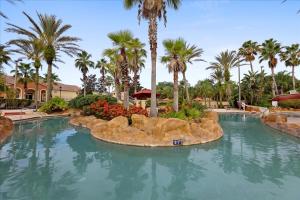 a large swimming pool in a resort with palm trees at Resort w Lazy River and Arcade 30mis to Disney in Davenport