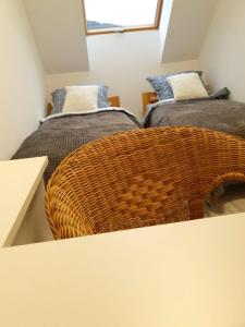 two twin beds in a small room with a w basket at Apartamenty z widokiem in Świeradów-Zdrój