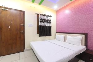 ein Schlafzimmer mit einem großen Bett und einer Holztür in der Unterkunft SHREE Ram hotel in Gorakhpur