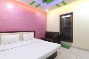 ein Schlafzimmer mit einem weißen Bett und einer rosa Wand in der Unterkunft SHREE Ram hotel in Gorakhpur