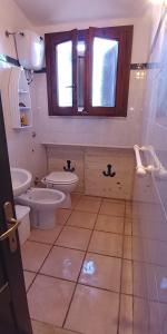 La salle de bains est pourvue de 2 toilettes, d'un lavabo et d'une fenêtre. dans l'établissement Casa vacanza Belvedere, à Torre Dei Corsari