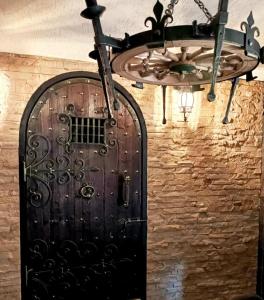 uma porta preta numa parede de tijolos com um lustre em Апартаменты в центре Ужгорода СКАЛА em Uzhhorod