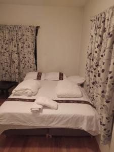 2 camas individuales en una habitación con cortinas en Nice 1-bedroom apartment in Heart of the City, en Stavanger