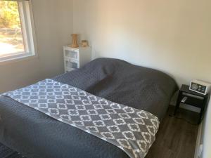 um quarto com uma cama com um cobertor e uma janela em Lakeland BoxCabin em Viitasaari