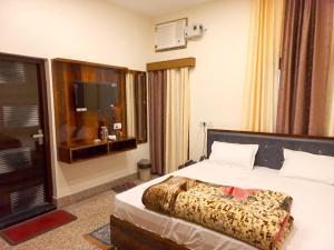 una camera d'albergo con letto e TV di Kalash Guest House a Ayodhya