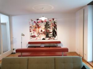 ein Wohnzimmer mit einem Sofa und einem Gemälde an der Wand in der Unterkunft exklusive Ferienwohnung in Architekten Villa, nähe Theater in Meiningen