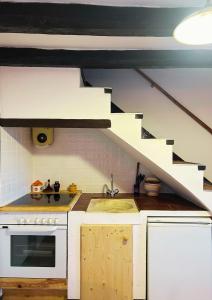 a kitchen with a stove and a sink and a staircase at Cal Xeco in Montsonis
