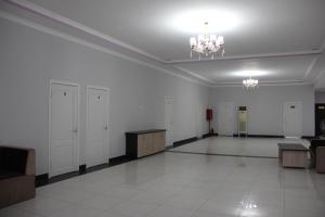 Großes Zimmer mit weißen Wänden und einem Kronleuchter in der Unterkunft Hostel Asham in Panjakent
